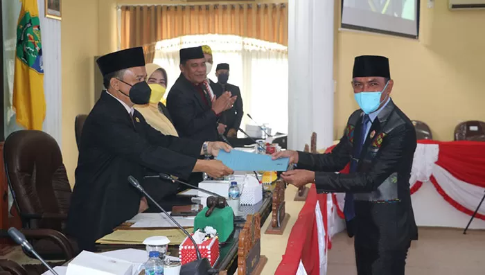 BERIKAN PANDANGAN UMUM: Ketua Komisi I DPRD Bulungan Alimuddin (kanan) menyerahkan catatan kepada pemerintah daerah.