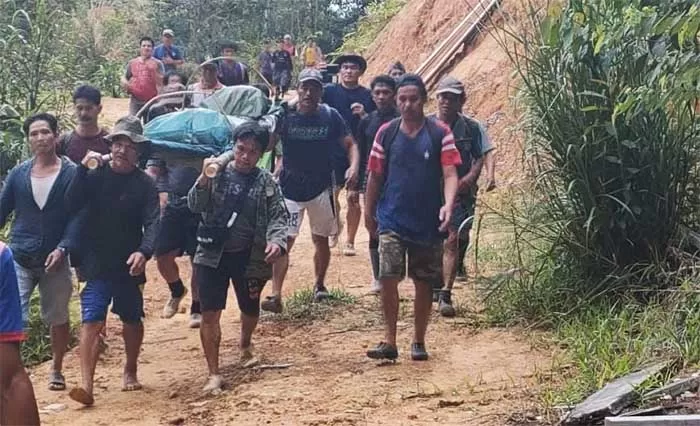 BERJALAN KAKI: Puluhan warga Wa’yagung Krayan bergantian mengusung jenazah Amos menuju rumah duka berjarak sekitar 20 km dari ibu kota kecamatan.