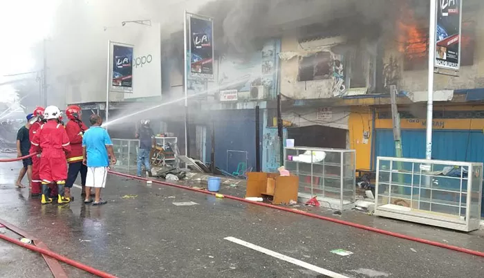 BERJIBAKU: Petugas pemadam kebakaran Tarakan dibantu masyarakat berusaha memadamkan api yang menghanguskan bangunan.