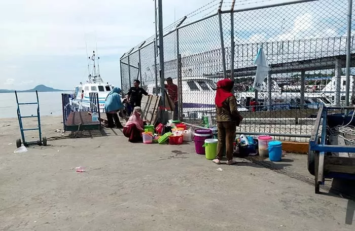 STERILISASI DARI PEDAGANG: Sejumlah pedagang asongan yang mengantre di areal Pelabuhan Tunon Taka menunggu penumpang kapal turun untuk membeli.