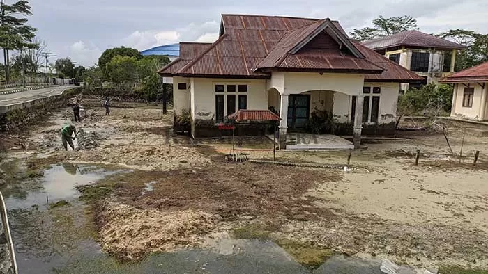 SEMPAT MANGKRAK: Pemkab Bulungan lakukan pengeringan genangan air yang merendam bekas bangunan KUA Tanjung Selor. Kondisi bangunan KUA saat tergenang air (foto kanan).