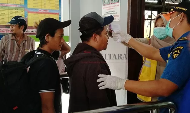 PENYEBERANGAN: Petugas masih melakukan pemeriksaan suhu tubuh kepada calon penumpang di Pelabuhan Malundung Tarakan.