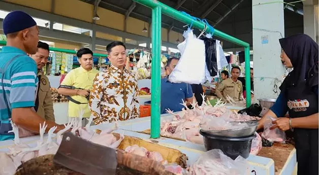 MEMASTIKAN STOK PANGAN: Bupati KTT Ibrahim Ali (batik) saat lakukan peninjauan Bapokting di pasar tradisional.