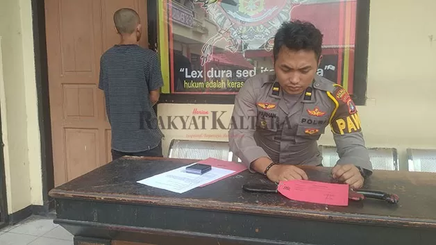 BACOK TETANGGA: Tersangka RM (kiri) saat diamankan bersama barang bukti berupa parang yang disita personel Polres Tarakan, Senin (7/11).