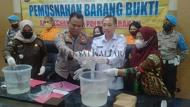 DILARUTKAN: Polisi bersama aparat penegak hukum dari BNN dan Kejari Tarakan memusnahkan narkotika jenis sabu dengan cara dilarutkan dalam ember berisi air, Kamis (17/11).