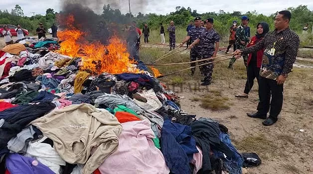 PEMUSNAHAN BARANG BUKTI: Ratusan balpres berisi pakaian bekas ilegal dimusnahkan dengan cara dibakar di lahan kosong di Jalan Hake Babu, Kelurahan Karang Harapan, Jumat (27/1).