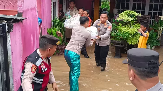 EVAKUASI: Kapolres Lampung Utara bersama jajarannya turun langsung untuk membantu warga korban banjir.