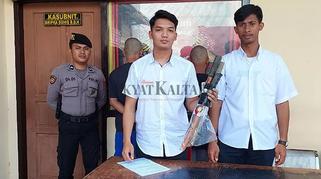 PENGARUH MIRAS: Dua tersangka (di belakang) dugaan pengeroyokan diamankan bersama barang bukti di Mako Polres Tarakan, Rabu (15/3).
