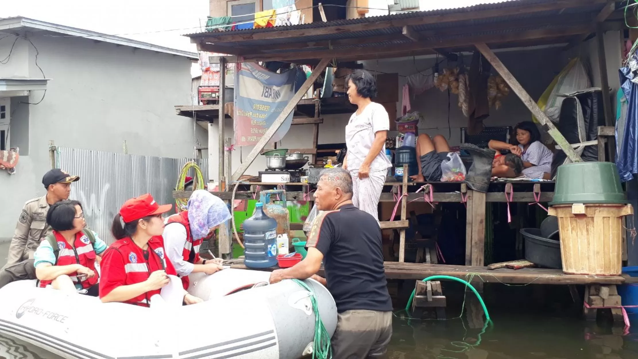 Petugas mengunjungi warga yang terpapar banjir.