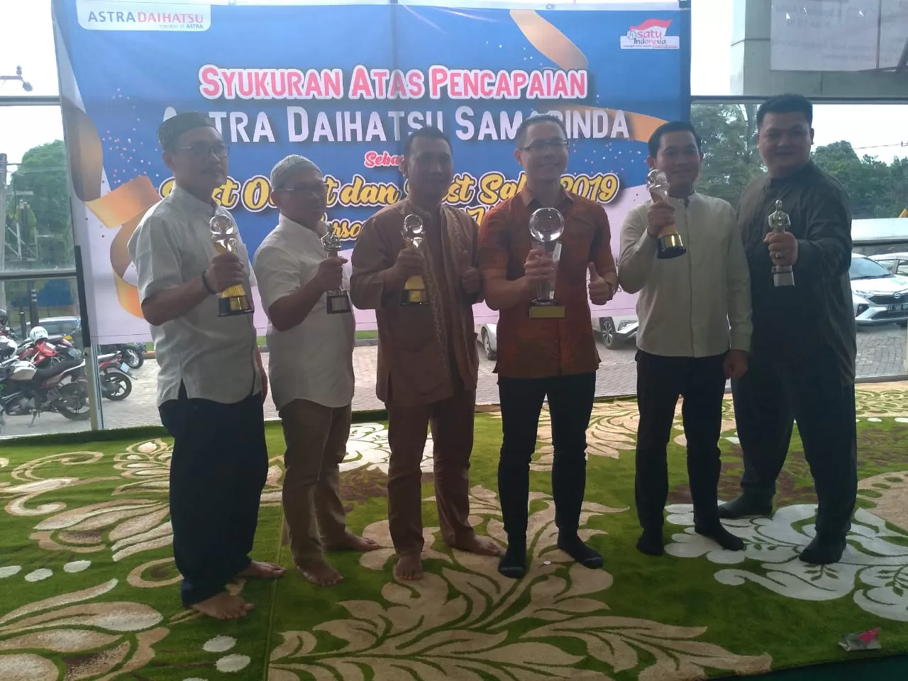 BACK TO BACK. Jajaran Astra Daihatsu Samarinda mengangkat piala atas prestasi mereka sebagai best outlet dan best sales Daihatsu se-Indonesia, bersama para anak yatim piatu di acara syukuran keberhasilan tersebut.