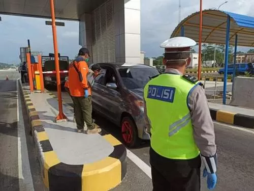 Petugas memeriksa setiap kendaraan dan penumpangnya saat memasuki tol Balikpapan-Samarinda.