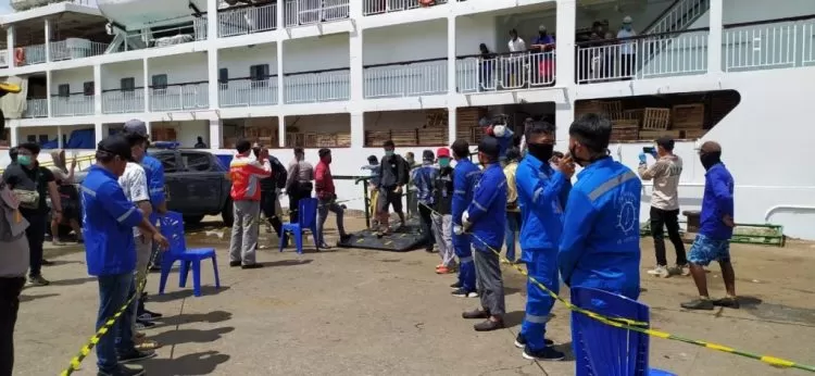 Petugas membuat barikade manusia untuk memastikan penumpang kapal yang turun di pelabuhan Samarinda melalui tes kesehatan.
