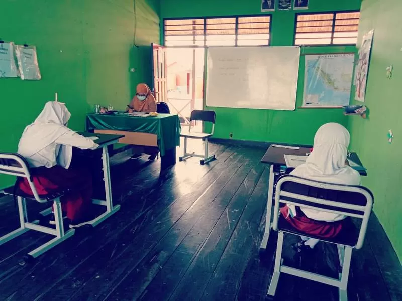 SERIUS: Dua pelajar di SD 015 Bontang Selatan sedang mengerjakan soal ujian sekolah.