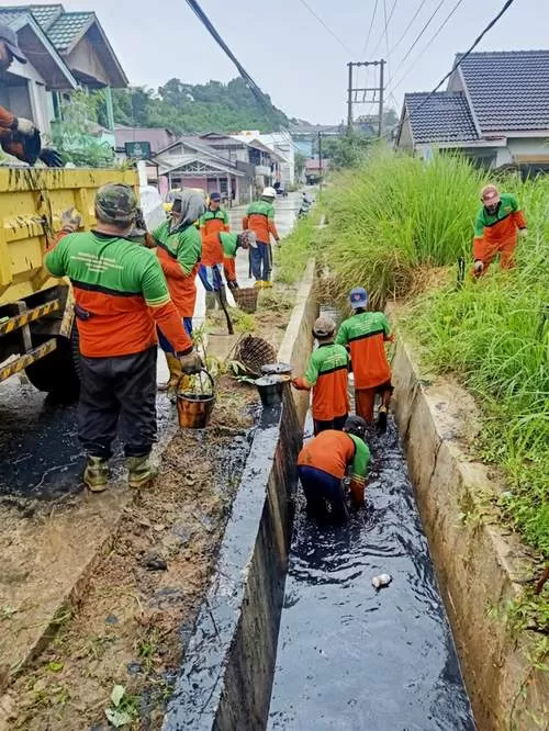 DIBERSIHKAN: Tim Hantu Banyu dari Dinas PUPR Samarinda ikut membersihkan saluran air saat gotong royong warga Kelurahan Gunung Kelua di sekitar Jalan Pramuka, Minggu (28/11).