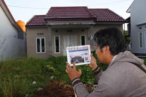 BERBURU RUMAH MURAH: Seorang warga mengecek rumah di Jalan Menteng II, Sampit, seperti yang terpampang dalam website rumahmurahbtn.co.id. Portal ini menawarkan 78 unit rumah yang tersebar di Kalimantan Tengah dengan harga di bawah pasaran. Penjualannya dengan mekanisme lelang melalui Kantor Pelayanan Kekayaan Negara dan Lelang (KPKNL) maupun penjualan langsung.(HENY PUSNITA/RADAR SAMPIT)