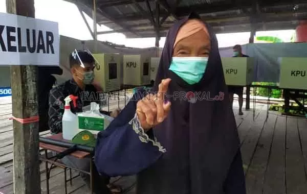 Seorang nenek memamerkan jari bertinta usai mengikuti pemungutan suara di salah satu TPS di Sampit, Kotawaringin Timur, Rabu  (9/12) lalu. (USAY NOR RAHMAD/RADAR SAMPIT)