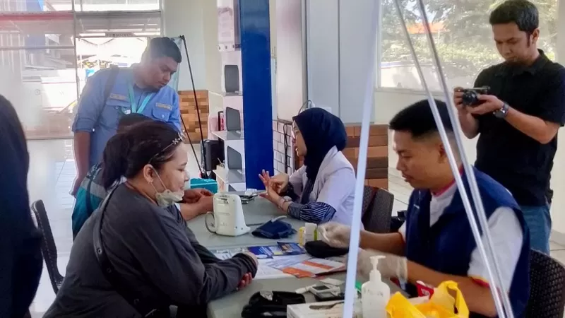 Petugas medis melayani pemeriksaan kesehatan penumpang di pos kesehatan stasiun wilayah KAI Divre II Sumbar selama masa Angkutan Lebaran Idul Fitri 1447 Hijriah. (Dok. KAI Divre II Sumbar)