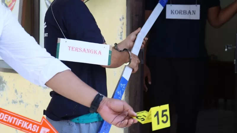 Rekonstruksi kasus pembunuhan pensiunan ASN di Polres Pasaman Barat memperlihatkan tersangka NJ memperagakan salah satu adegan saat menghabisi korban di pondok kebun. Rekonstruksi digelar pada Senin (13/4/2026) siang. (Dok. Polres Pasbar)