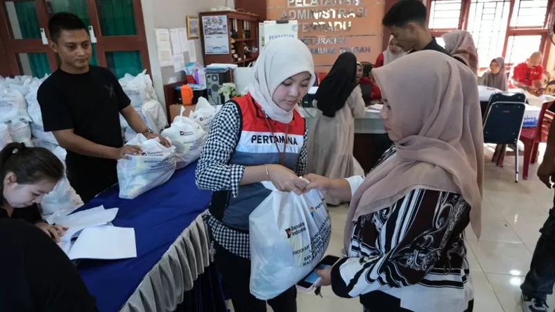 Petugas Pertamina Patra Niaga Regional Sumbagut menyerahkan paket sembako kepada warga dalam Program Pasar Murah di Kelurahan Teluk Kabung Tengah, Kecamatan Bungus Teluk Kabung, Kota Padang, Kamis (16/4/2026). Program ini menyediakan 1.000 paket kebutuhan pokok dengan harga terjangkau guna membantu masyarakat pra sejahtera memenuhi kebutuhan sehari-hari. (Dok. PPN Sumbagut)