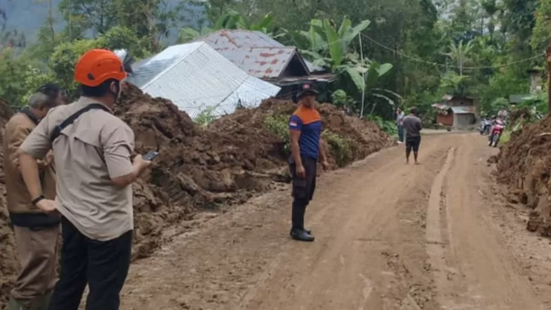 Petugas gabungan membersihkan material tanah longsor yang menutup badan jalan di kawasan Sungai Landia, Agam, Sumatera Barat (Sumbar) usai bencana yang sempat melumpuhkan lalu lintas. (Dok. BPBD Agam)