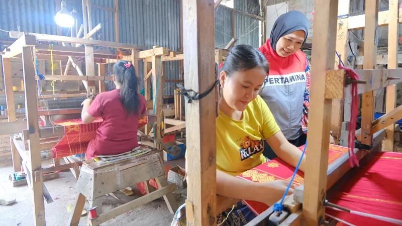 Sejumlah penenun lokal menyelesaikan produk kain ulos di Sakkamadeha Gallery and Workshop, Desa Lumban Suhi Suhi Toruan, Kabupaten Samosir, Sumatera Utara. Dukungan Pertamina Patra Niaga Regional Sumbagut mendorong pengembangan UMKM berbasis budaya lokal sekaligus memperkuat ekonomi kreatif masyarakat. (Dok. PPN Sumbagut)