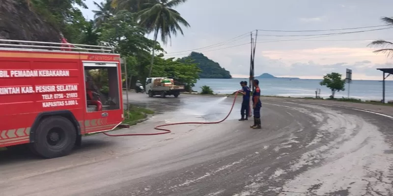  Personel Bidang Kebakaran dan Penyelamatan Kabupaten Pesisir Selatan bergerak cepat membersihkan material lumpur yang menutupi badan Jalan Sutan Syahrir di kawasan Pincuran Boga, Painan Selatan, Kecamatan IV Jurai. (Foto: Pemkab Pessel)