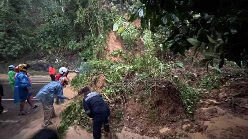 Petugas gabungan melakukan penanganan material longsor dan pohon tumbang yang menutup Jalan Raya Padang-Painan KM 16 di Kelurahan Bungus Barat, Kecamatan Bungus Teluk Kabung, Padang, Minggu (14/6/2026) sore. (Dok. Pusdalops PB)