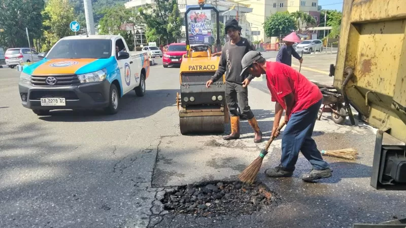Personel Dinas PUPR Kota Padang melakukan kegiatan pemeliharaan rutin dan penambalan jalan di sejumlah titik strategis Kecamatan Padang Selatan, Minggu (21/6/2026), guna meningkatkan keselamatan dan kelancaran mobilitas masyarakat. (Dok. PUPR Padang)