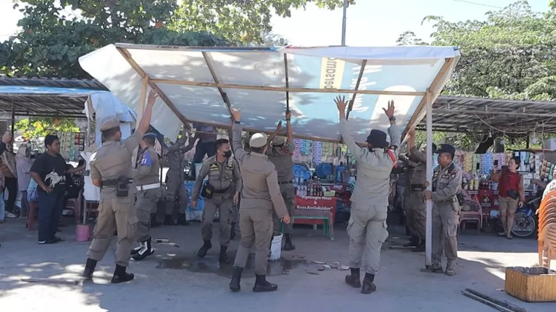Petugas Satpol PP Kota Padang bersama tim gabungan melakukan pembongkaran bangunan tambahan milik pedagang yang melanggar ketentuan di kawasan Pusat Kuliner Pantai Padang, Selasa (23/6/2026) siang. (Dok. Humas)