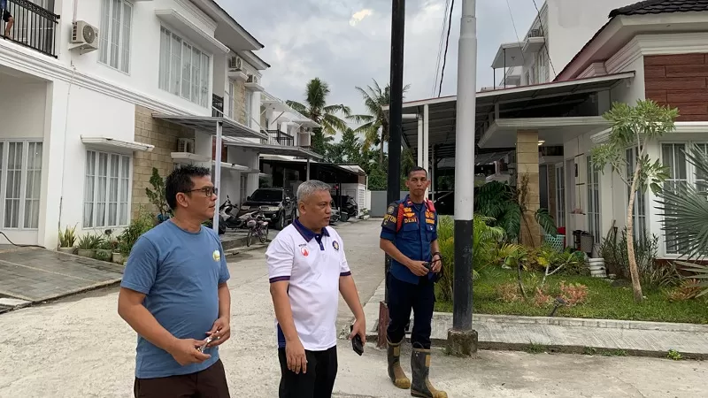 Kepala Dinas Pemadam Kebakaran (Kadis Damkar) Kota Padang, Budi Payan (tengah, mengenakan baju putih), hadir langsung di lokasi untuk memantau proses pemadaman kebakaran rumah dan lahan di Cluster Menara Village, Kelurahan Gunung Pangilun, Kecamatan Padang Utara, Rabu (15/7/2026) sore. Kehadiran Budi Payan memastikan penanganan berjalan optimal hingga api berhasil dikendalikan dan tidak meluas ke bangunan lain. (Dok. Padang Fire Fighter)