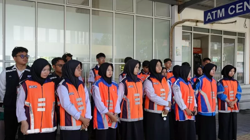 Mahasiswa Universitas Dharma Andalas (Unidha) bersama siswa SMKN 6 Padang dan KAI Divre II Sumbar menggelar sosialisasi disiplin berlalu lintas di perlintasan sebidang KM 0+805 Padang-Pulau Air, Selasa (21/7/2026), sebagai upaya meningkatkan keselamatan perjalanan kereta api. (Dok. KAI)
