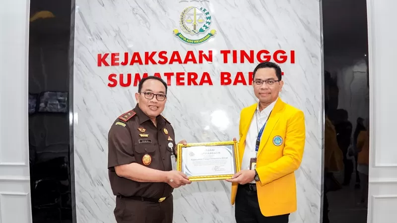 Rektor Universitas Negeri Padang (UNP), Krismadinata menyerahkan Piagam Penghargaan kepada Kepala Kejaksaan Tinggi Sumatera Barat (Kajati Sumbar), Dedie Tri Haryadi atas keberhasilan Bidang Perdata dan Tata Usaha Negara memulihkan aset negara lebih dari Rp2,2 miliar dan menyelamatkan keuangan negara lebih dari Rp8 miliar, Selasa (21/7/2026) siang. (Dok. Penkum)