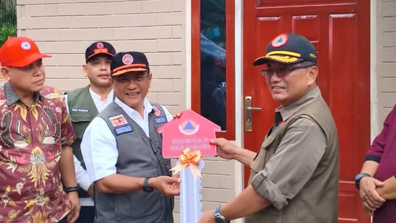 Sekretaris Utama Badan Nasional Penanggulangan Bencana (BNPB), Rustian, S.Si., Apt., M.Kes., menyerahkan langsung kunci huntap mandiri kepada warga pada Jumat (10/7/2026). (Foto: BNPB)