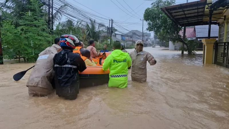 Petugas gabungan dari Polresta Padang, Basarnas, dan tim SAR mengevakuasi warga dari kawasan terdampak banjir setelah hujan deras menyebabkan sungai meluap di sejumlah kecamatan di Kota Padang, Senin (3/8/2026) siang. (Dok. Humas)