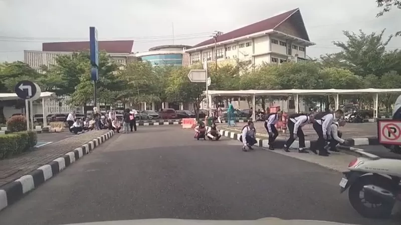 Mahasiswa baru (Maba) Universitas Negeri Padang (UNP) mengenakan seragam hitam putih dan sejumlah atribut saat mengikuti kegiatan di lingkungan kampus. Aktivitas jalan jongkok yang dilakukan sebagian maba kemudian menjadi sorotan setelah videonya beredar. (Dok. Istimewa)