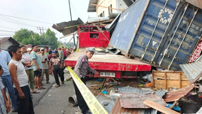 Truk kontainer BA 8360 QC mengalami kecelakaan tunggal setelah rem blong dan menabrak tiga rumah warga di Jalan Pampangan Simpang Natraco, Lubuk Begalung, Kota Padang pada Selasa (8/9/2026) sore. (Dok. Polsek Lubuk Begalung/Kompol Robby Setiadi Purba)