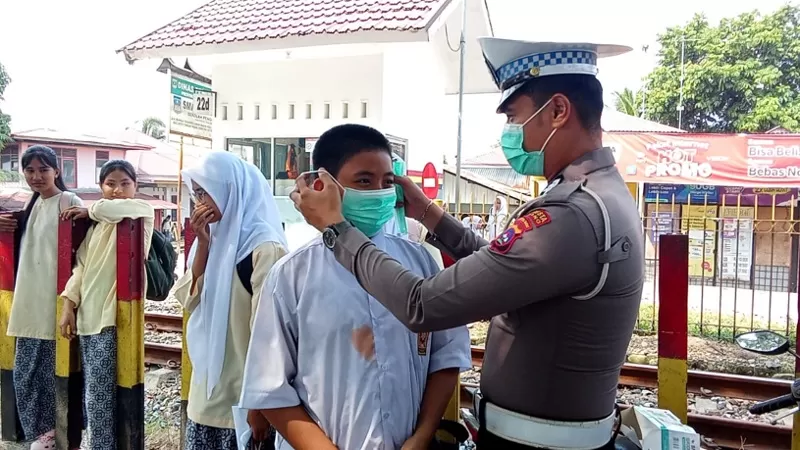 Personel Polsek Koto Tangah, Polresta Padang, membagikan masker kepada masyarakat, khususnya pelajar dan pengendara, sebagai langkah perlindungan dari paparan kabut asap akibat karhutla, Selasa (8/9/2026) siang. (Dok. Polsek Koto Tangah)