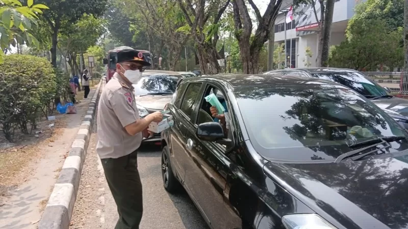 Petugas BPBD Kota Padang bersama KSB membagikan masker kepada masyarakat dan pengendara di salah satu titik pembagian masker di Kota Padang, Selasa (15/9/2026) siang. (Dok. Pusdalops PB)