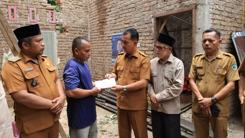 Rumah Em Hermanto (48), warga Kampung Koto, Jorong Simpang Tigo Timur, Nagari Simpang, Pasaman, mengalami kerusakan berat setelah tertimpa pohon karet dan pohon durian saat hujan lebat disertai angin kencang melanda wilayah tersebut pada Senin (22/9/2026) sore. (Foto: Pemkab Pasaman)
