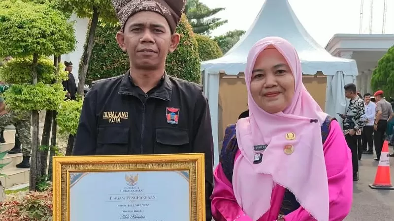 Dubalang Kelurahan Berok Nipah, Mai Hendra dan Lurah Berok Nipah, Sri Utari. Mai Hendra menerima penghargaan dari Gubernur Sumbar, Mahyeldi atas peran dalam program Intervensi Berbasis Masyarakat (IBM) di Halaman Istana Gubernur Sumbar, Kamis (1/10/2026). (Dok. Pribadi)