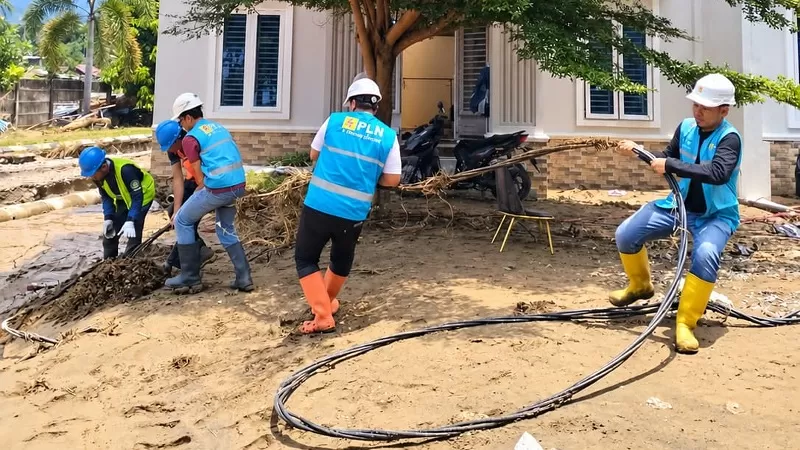 Petugas PLN Unit Induk Distribusi Sumatera Barat (UID Sumbar) melakukan penanganan jaringan listrik terdampak banjir di Kota Padang. Selain memulihkan pasokan listrik secara bertahap, PLN menyalurkan bantuan makanan kepada warga terdampak dan petugas gabungan. (Dok. Kom TJSL PLN)
