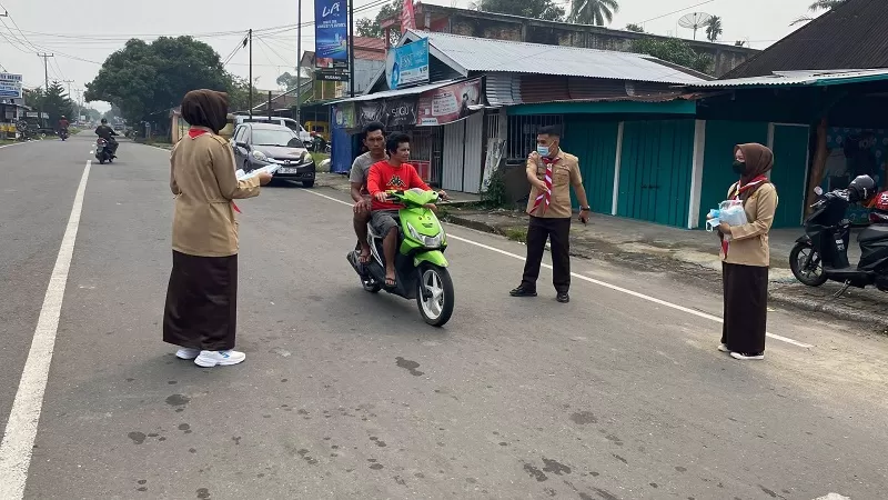Kwartir Cabang (Kwarcab) 0317 Gerakan Pramuka Kabupaten Pasaman Barat (Pasbar) membagikan 3.650 masker kepada pengguna jalan dan masyarakat di empat lokasi pada Jumat (16/10/2026). (Foto: Pemkab Pasbar)