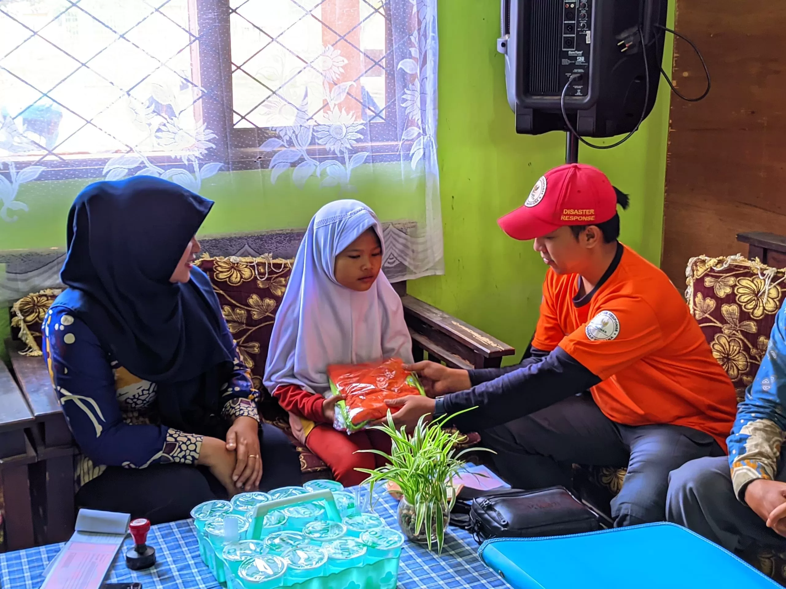 Petugas Baznas Menyerahkan Bantuan Seragam Sekolah