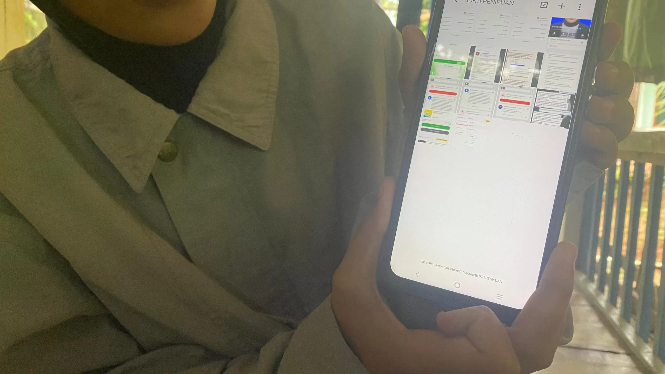Korban menunjukkan bukti dugaan penipuan lowongan kerja daring melalui telepon genggamnya di Cimanggung, Sumedang, Jumat (20/2/2026).