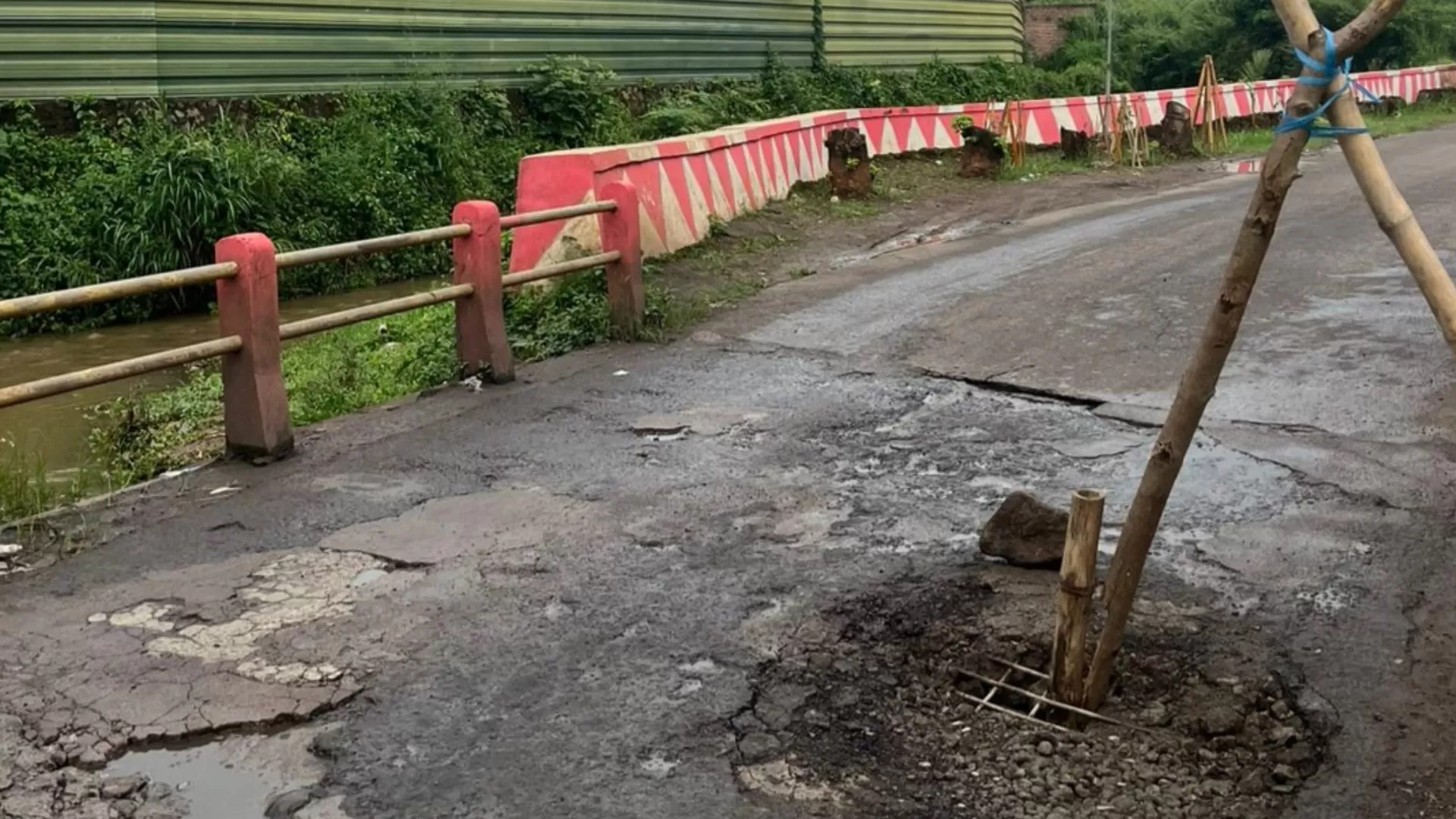 Kondisi jalan berlubang di atas jembatan Jalan Cimande, Dusun Cimande RT 01 RW 11, Desa Sindangpakuon, Kecamatan Cimanggung, Kabupaten Sumedang. Lubang pada badan jalan ditandai bambu oleh warga, Selasa (3/2/2026).