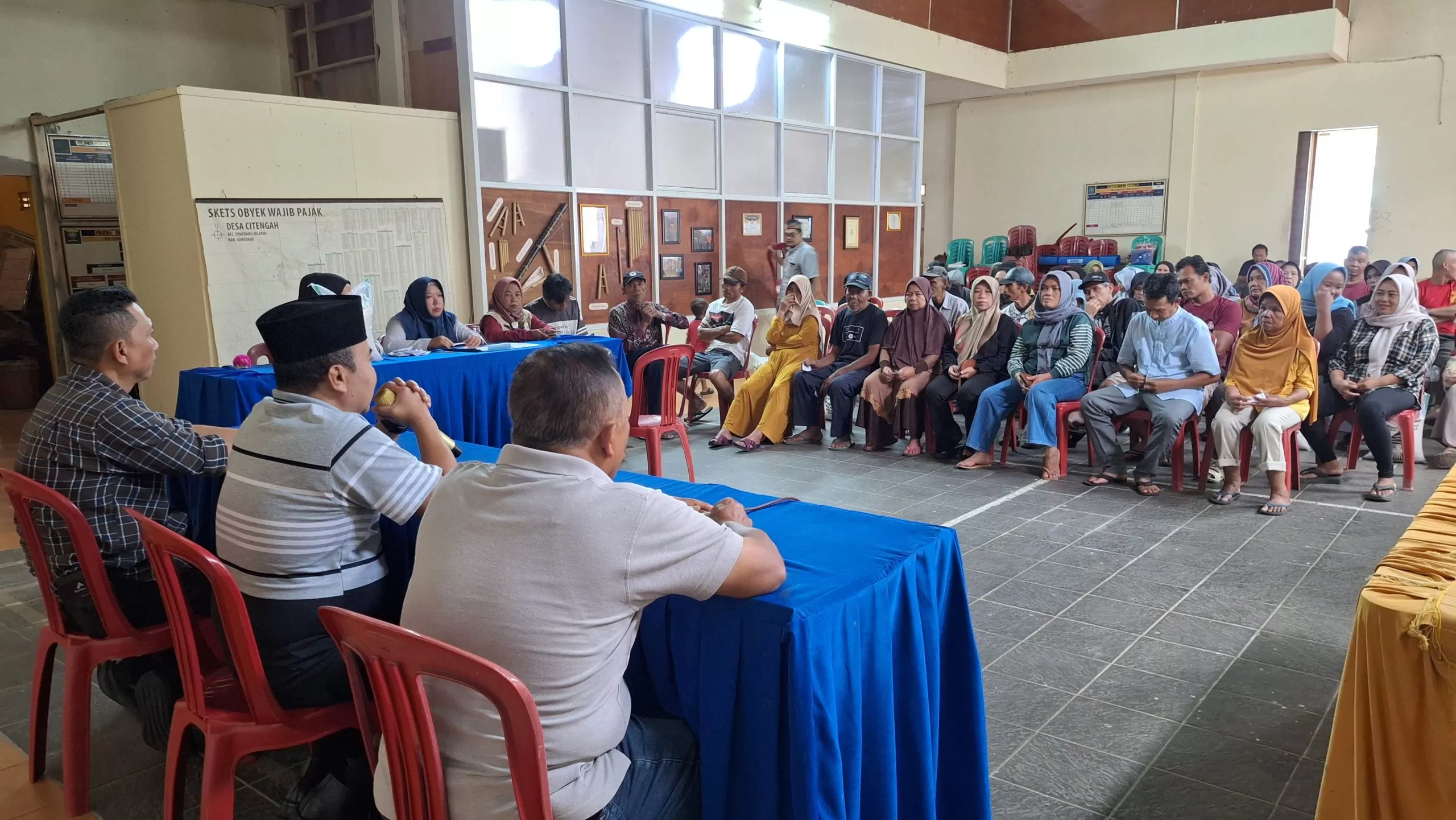 Foto: Proses penyaluran bantuan pangan dari Pemerintah Sumedang kepada masyarakat di kantor desa pada Minggu (15/3/2026).