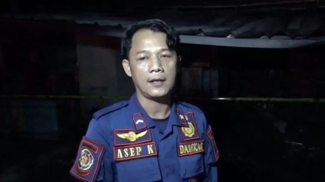 Komandan Regu 1 UPT Pemadam Kebakaran Conggeang, Asep K., saat diwawancara awak media di TKP, Senin (16/3/2026) malam. 