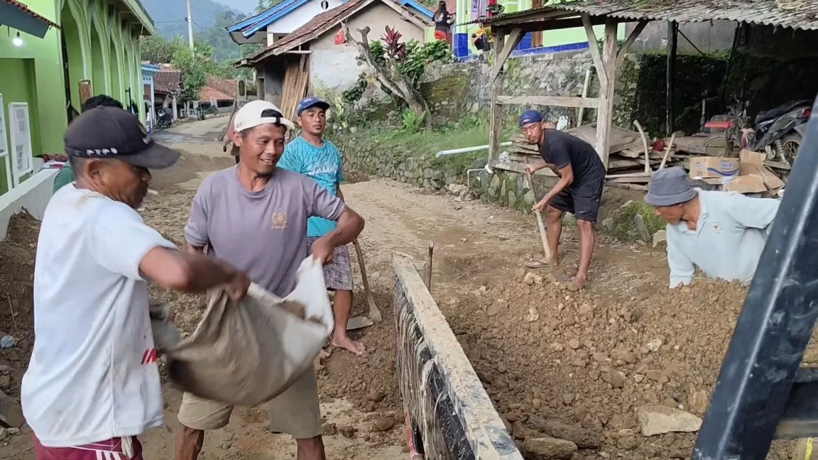 Warga Dusun Cisampih bergotong royong evakuasi material longsor yang menutup jalan, (29/03/2026).