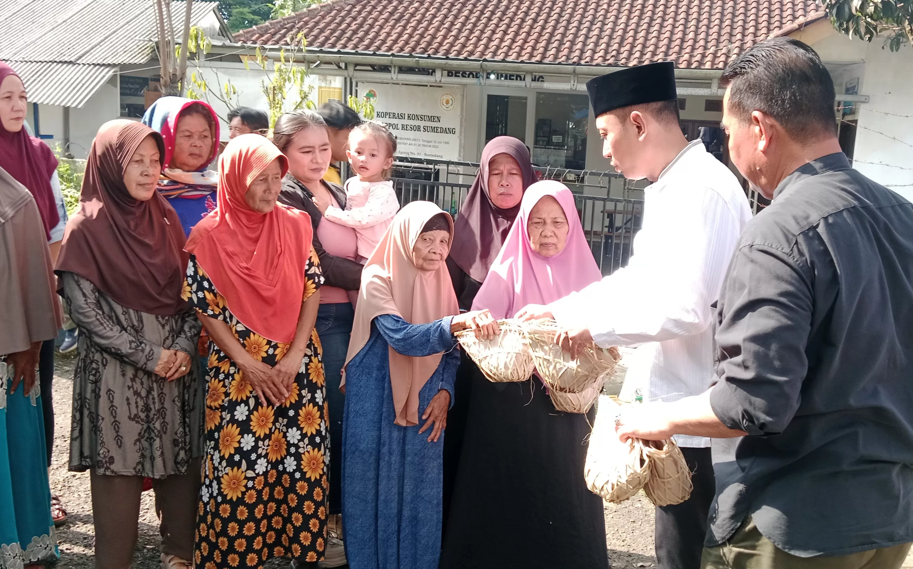 Kapolres Sumedang AKBP Sandityo Mahardika saat Membagikan Daging Hewan Kurban yang Dikemas Menggunakan Bongsang dan Daun Pisang (Foto : Istimewa)