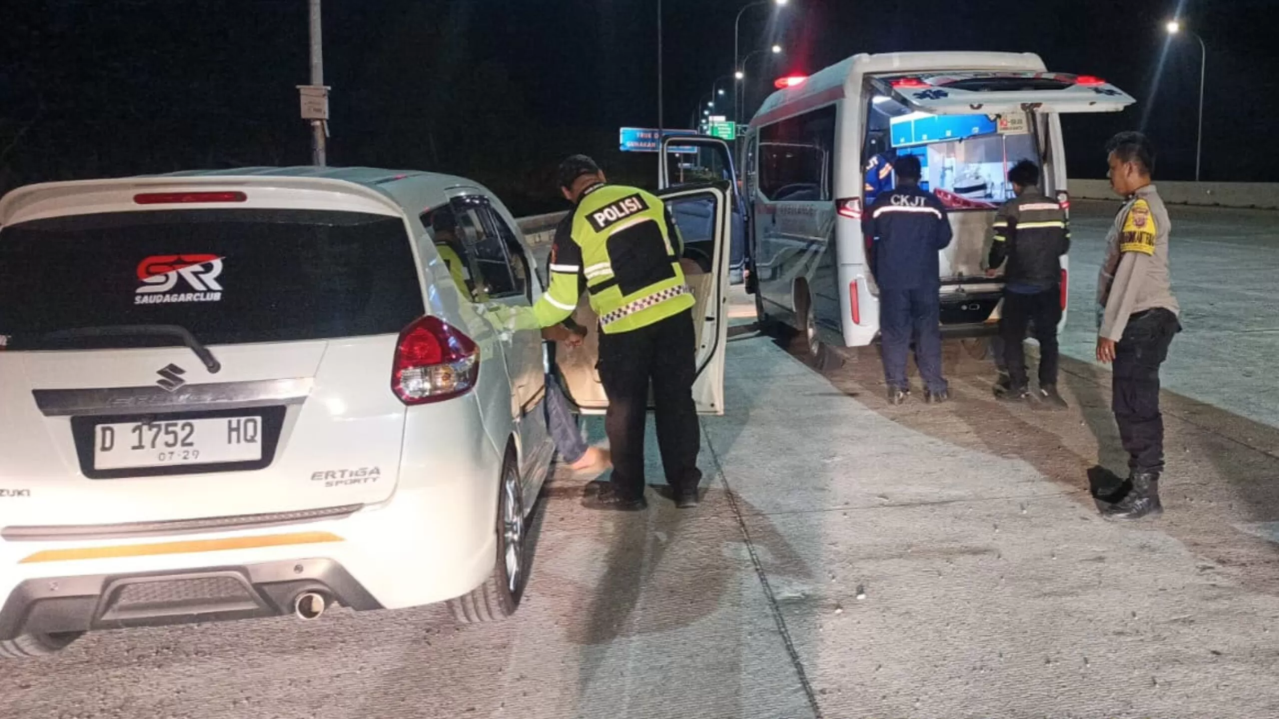 Petugas Polres Sumedang saat memberikan pertolongan kepada warga yang sakit di Tol Cisumdawu. (Foto : Istimewa)